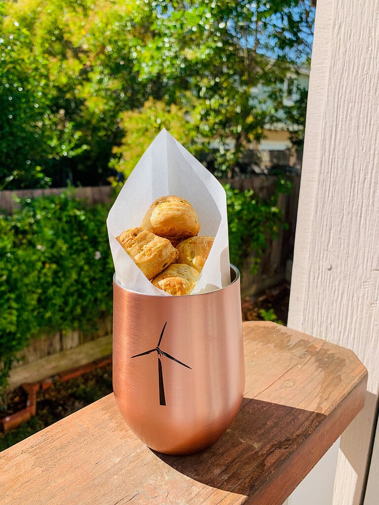 A handful of goat gouda gougères in an Anaba copper cup.