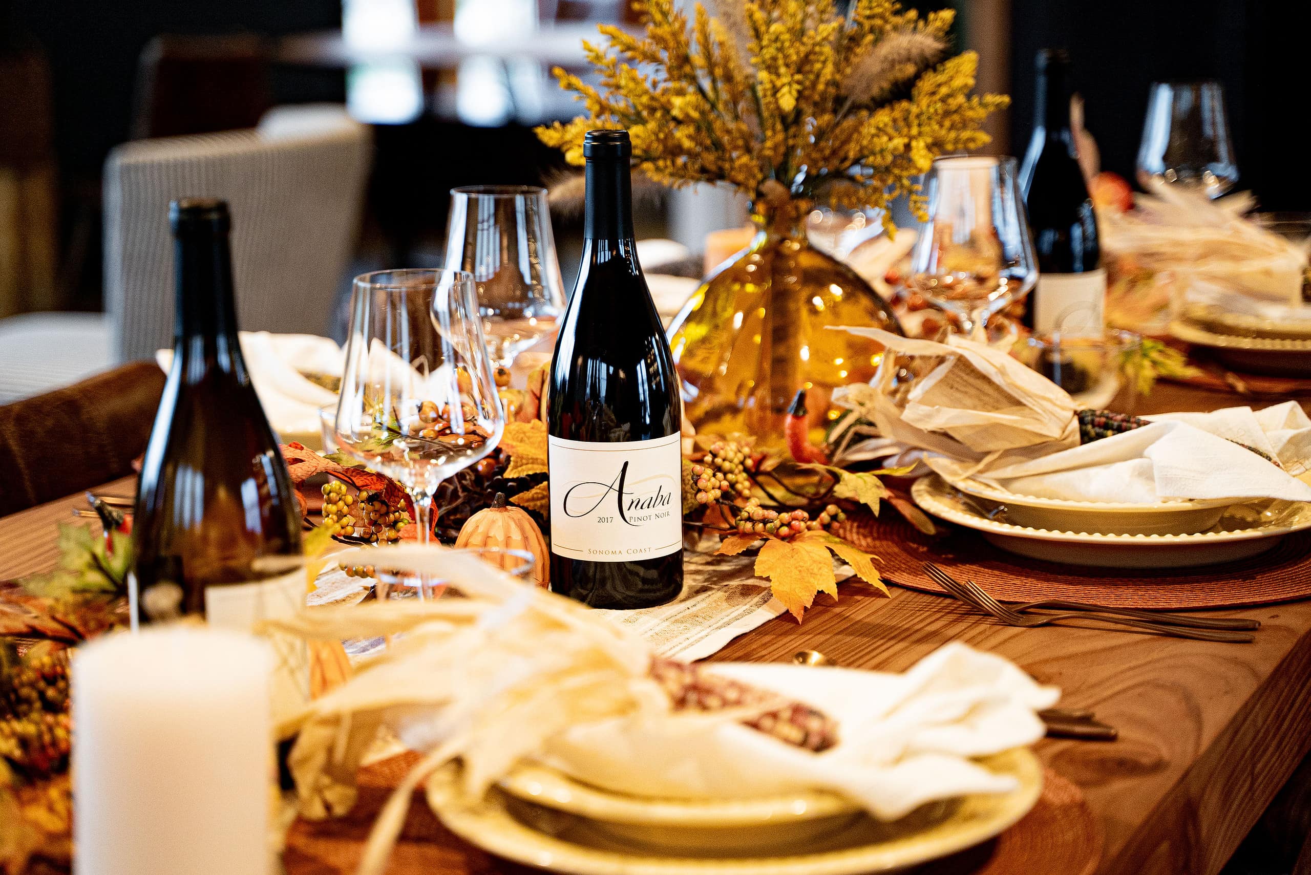 A thanksgiving dinner table is set with several Anaba wine bottles.
