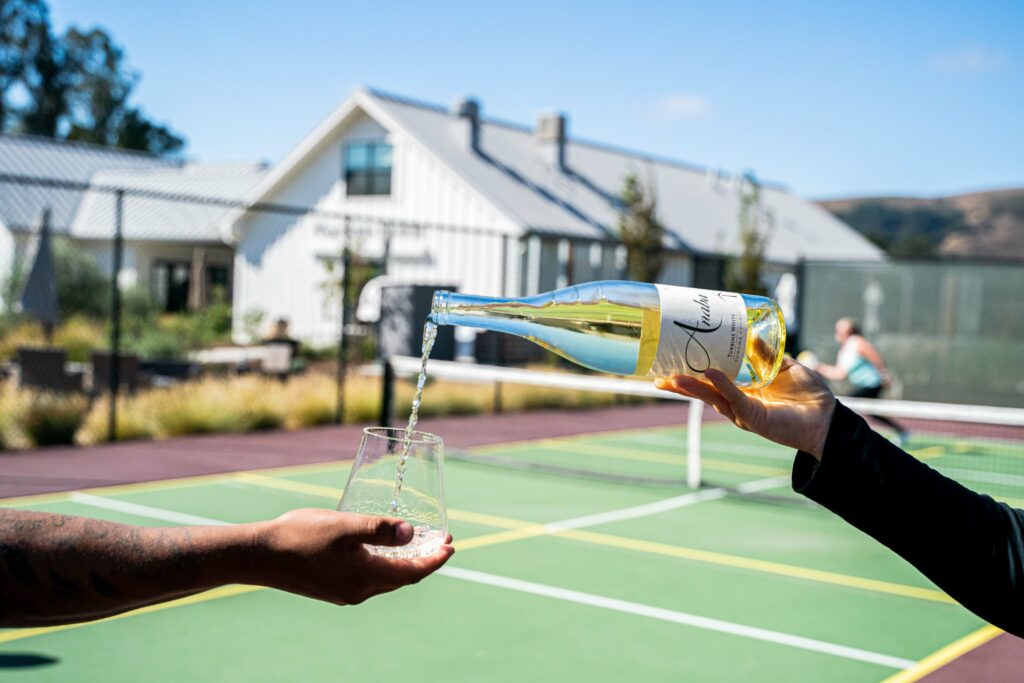 Pouring wine on Anaba's pickleball court.