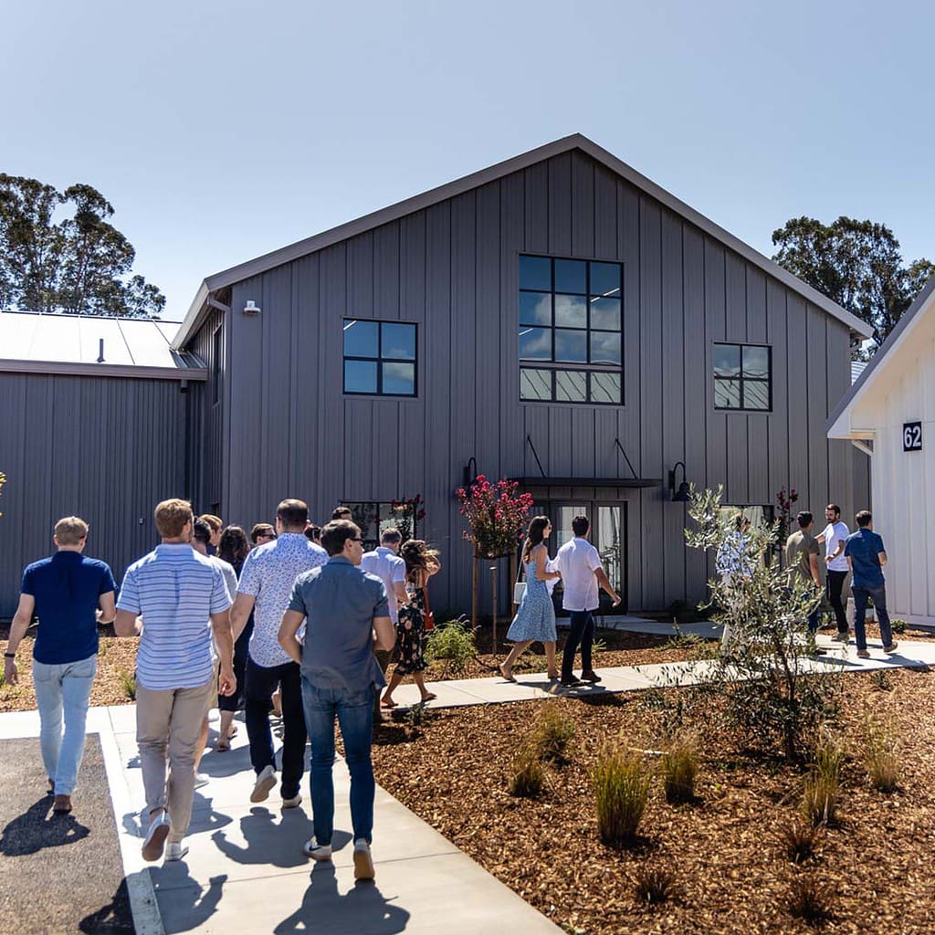 Groups of people entering Anaba Vineyard in the foreground, the building seen in the mid-ground. 