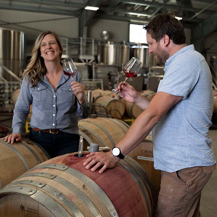 Katy and Ian standing over barrels in the Anaba winery. 