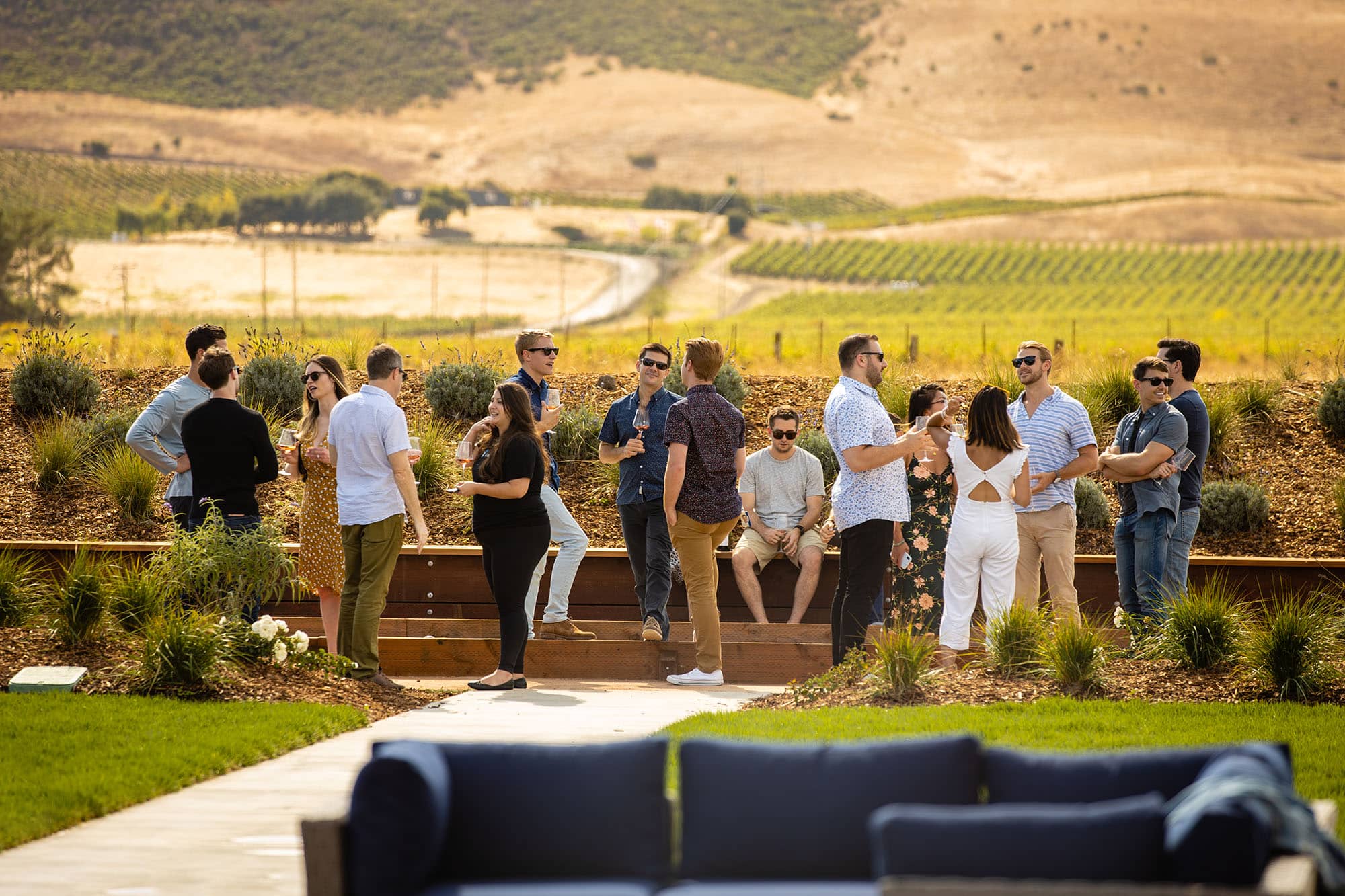 Large group of happy adults drinking wine at Anaba and overlooking the Sonoma vineyards