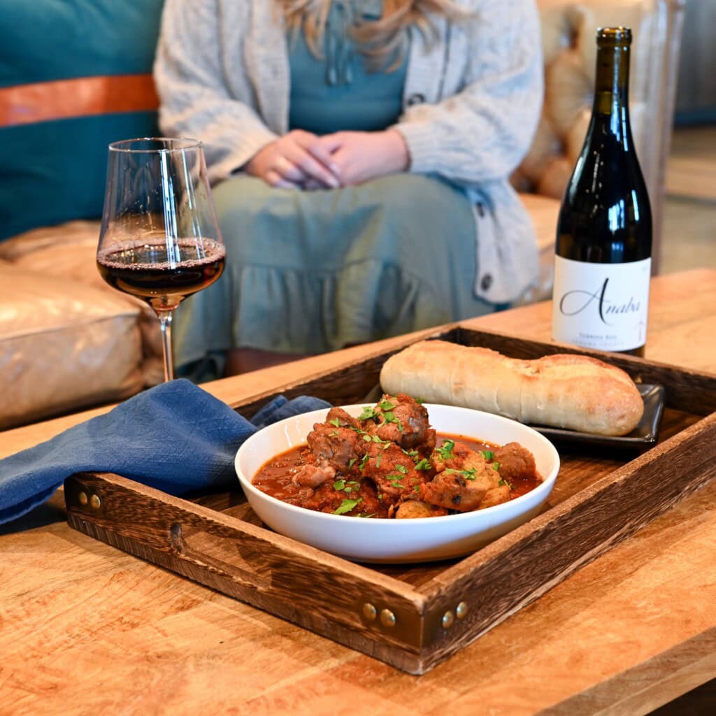 Big bowl of italian chicken stew, served with a bottle of Turbine Rhone Red